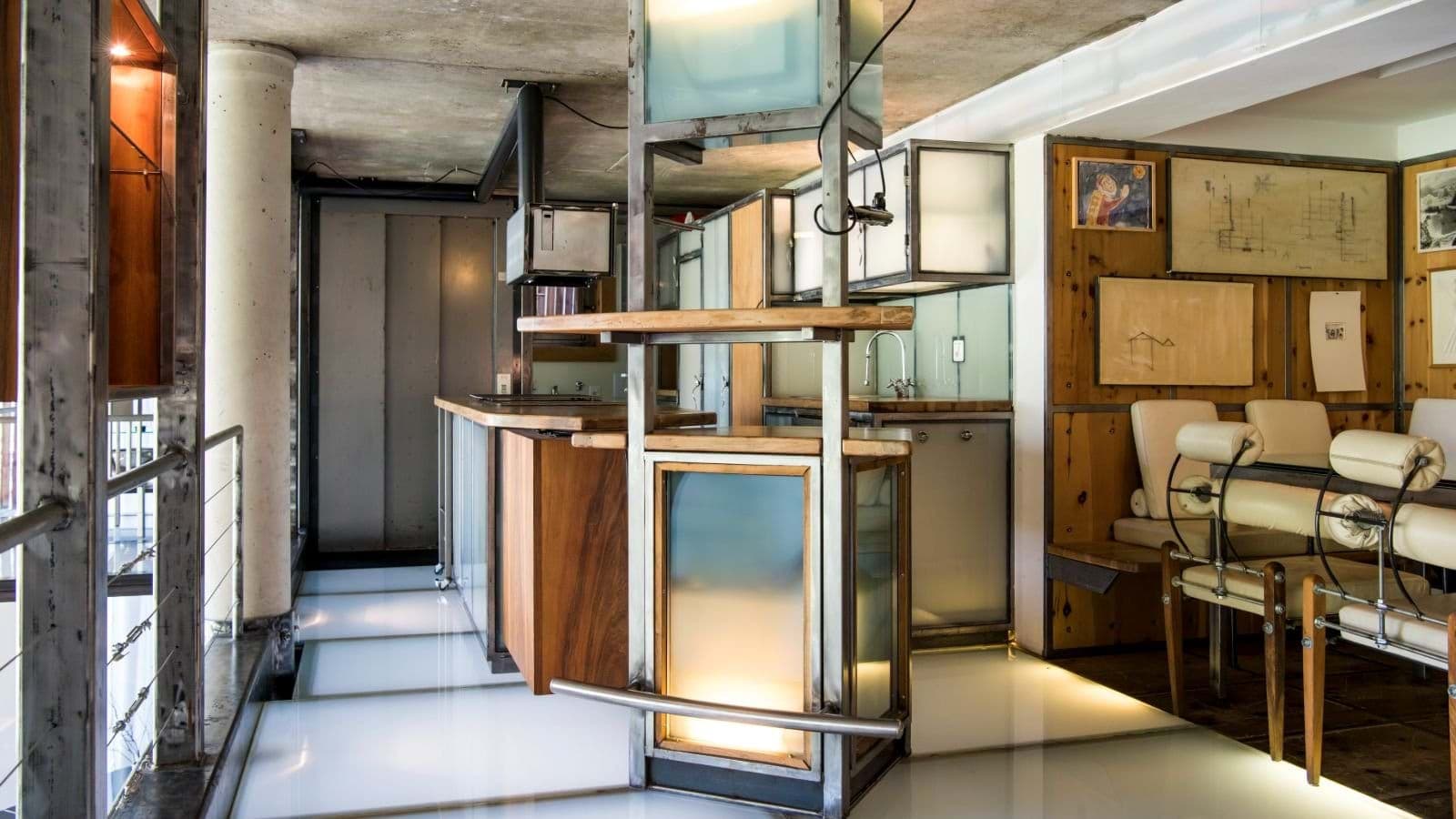 Industrial kitchen and dining area with glass floor and steel cabinetry
