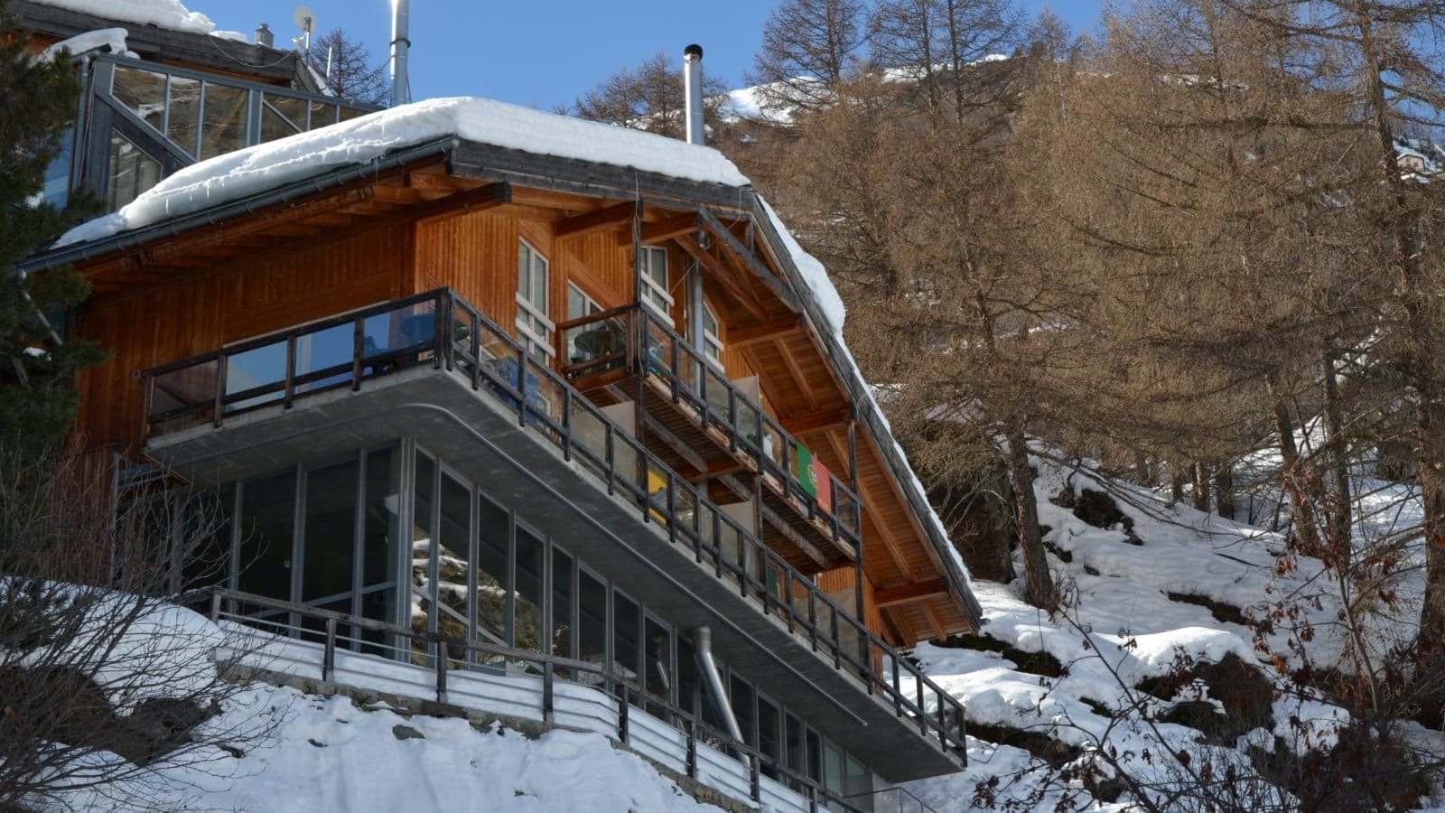 Chalet exterior with multi-level balconies and floor-to-ceiling windows