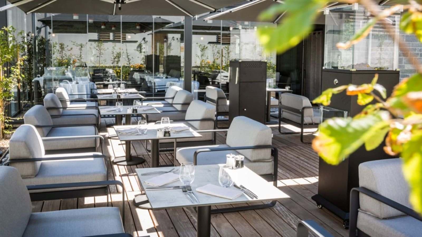 Outdoor terrace with lounge seating and glass-enclosed space heaters