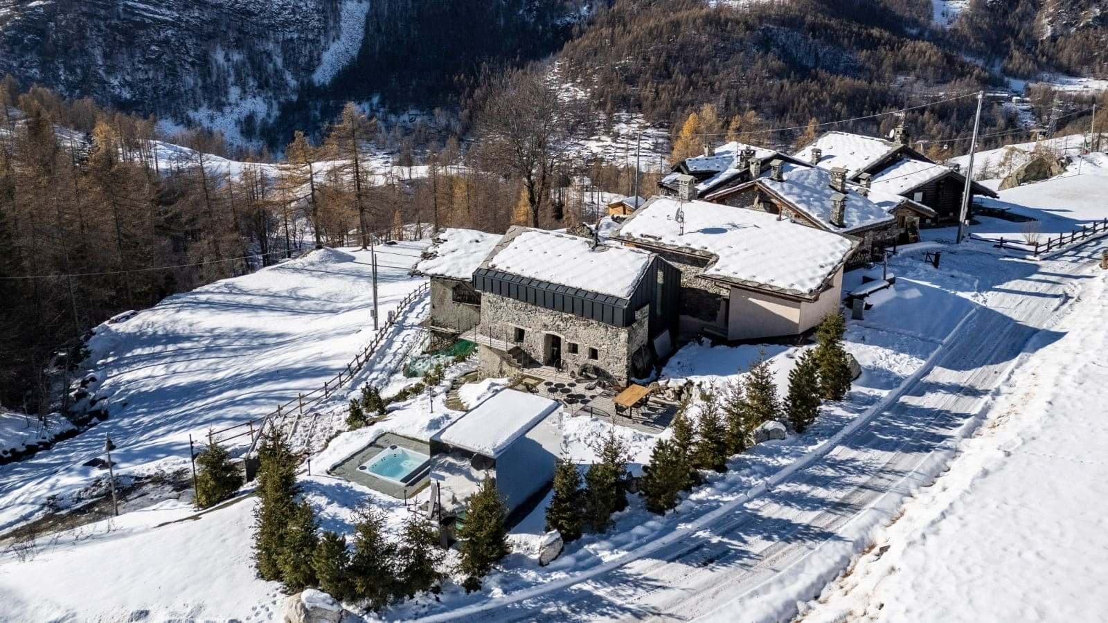Stone chalet exterior with private outdoor hot tub and valley views