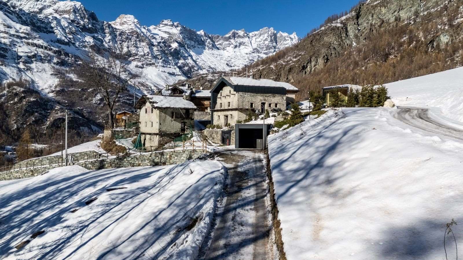 Stone chalet exterior with private garage and alpine mountain views