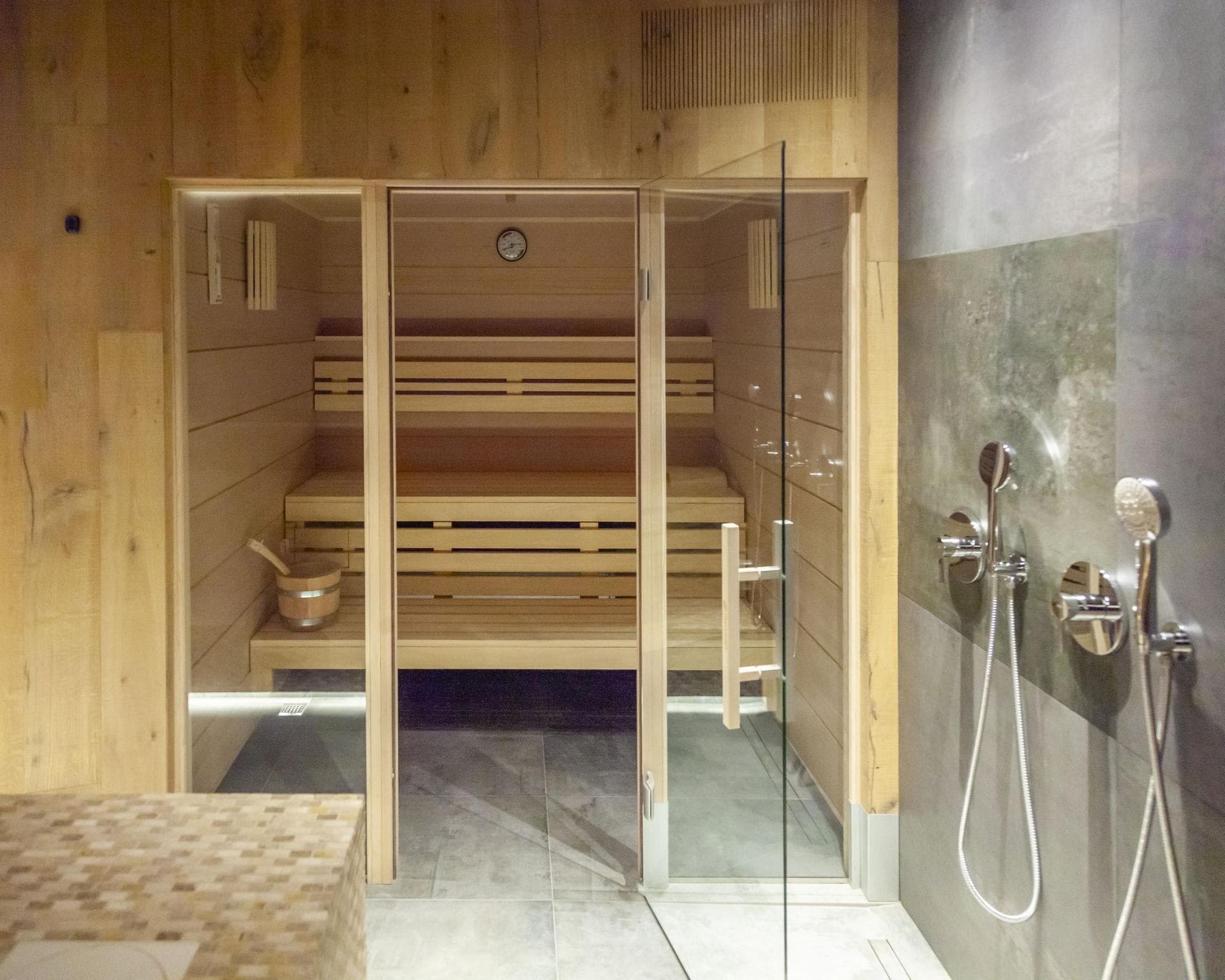 Private cedar sauna and adjacent shower area with dual showerheads