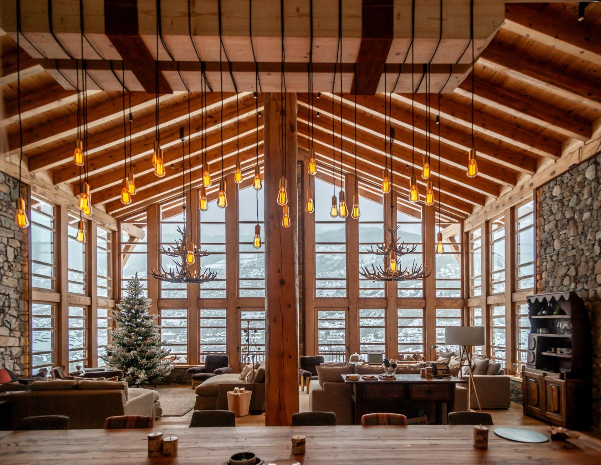 Great room with double-height windows and floor-to-ceiling mountain views