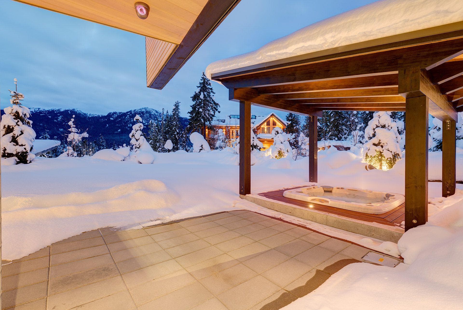 Covered outdoor hot tub with mountain views and patio access