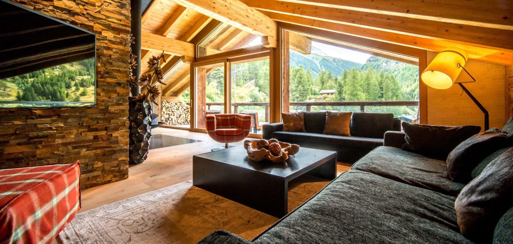Living area with floor-to-ceiling windows and forest views