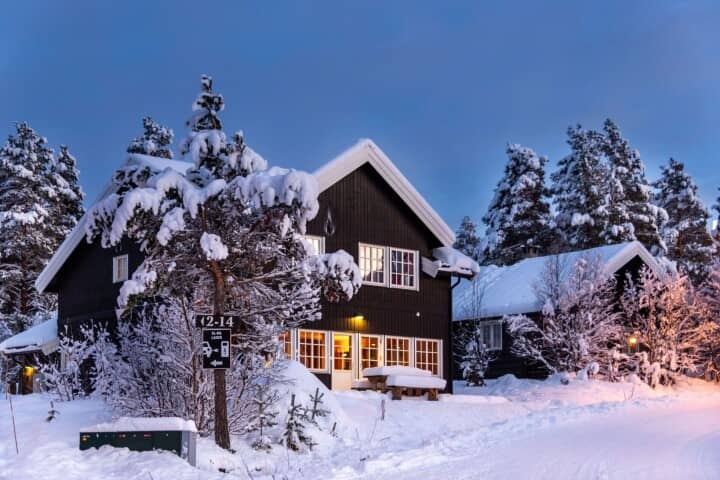 Two-story dark wood cabin with outdoor picnic table seating