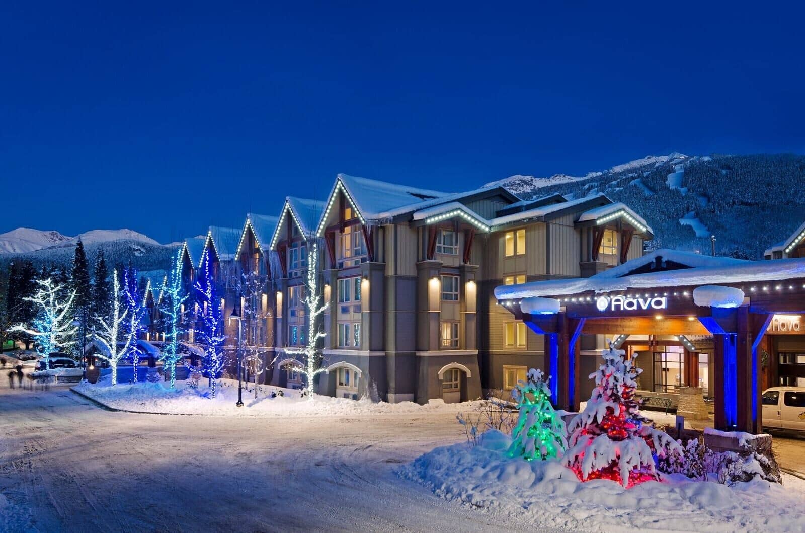 Ski resort exterior with lighted trees and mountain views