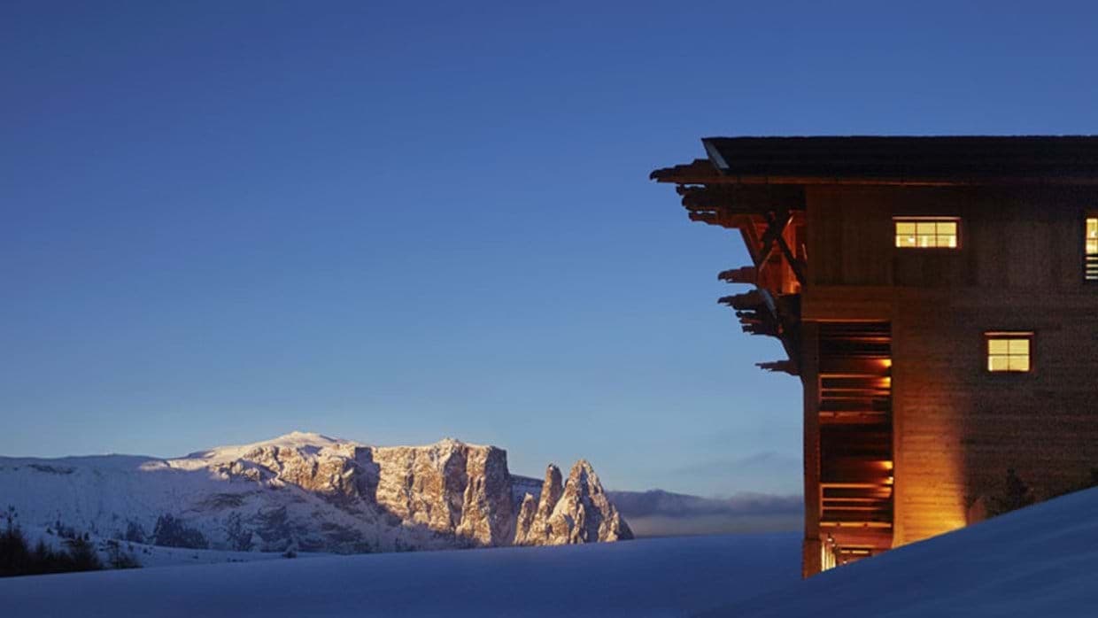 Dolomite mountain views from the timber chalet exterior at dusk