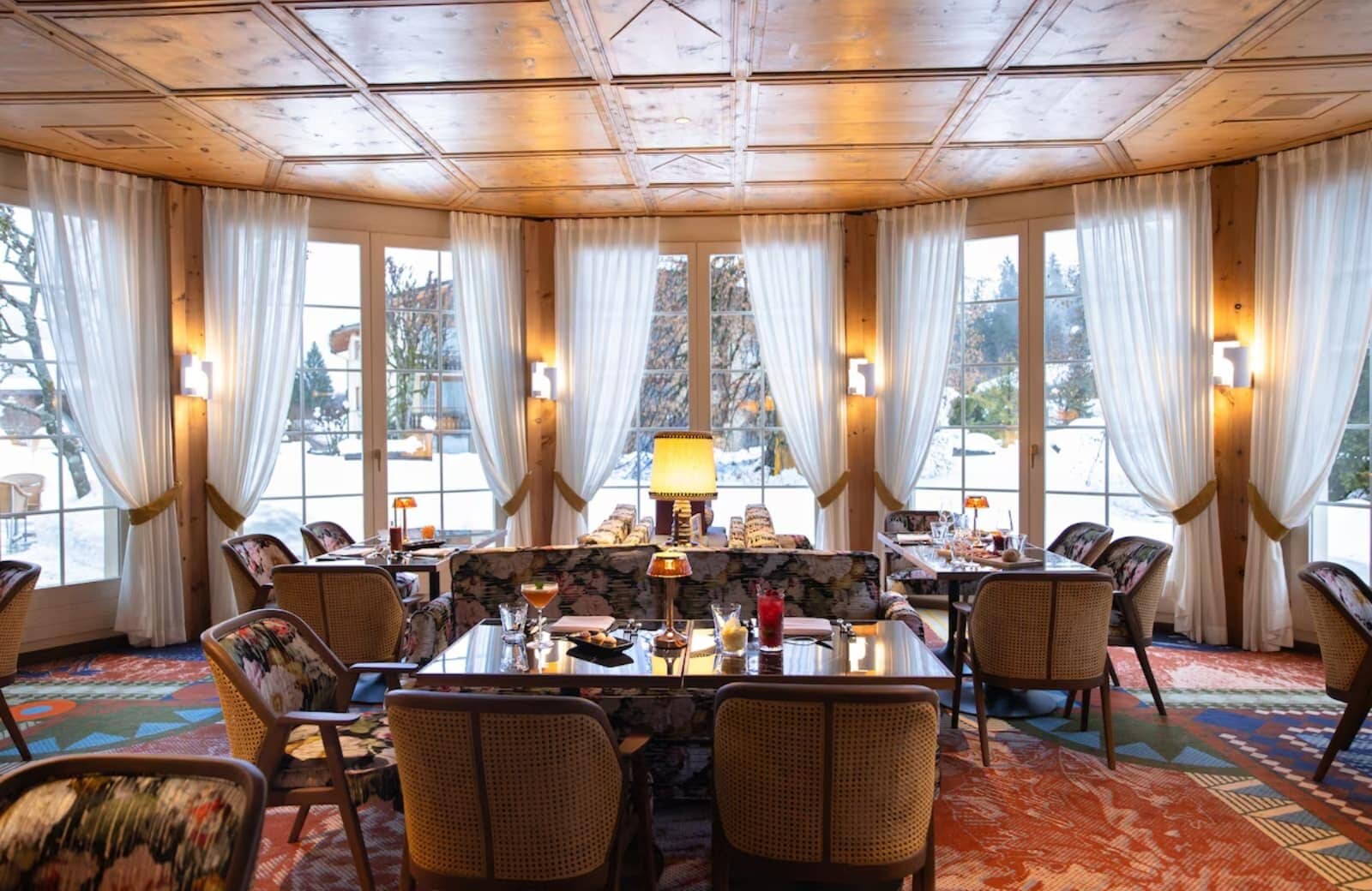 Dining area with wood coffered ceiling and snow-covered garden views