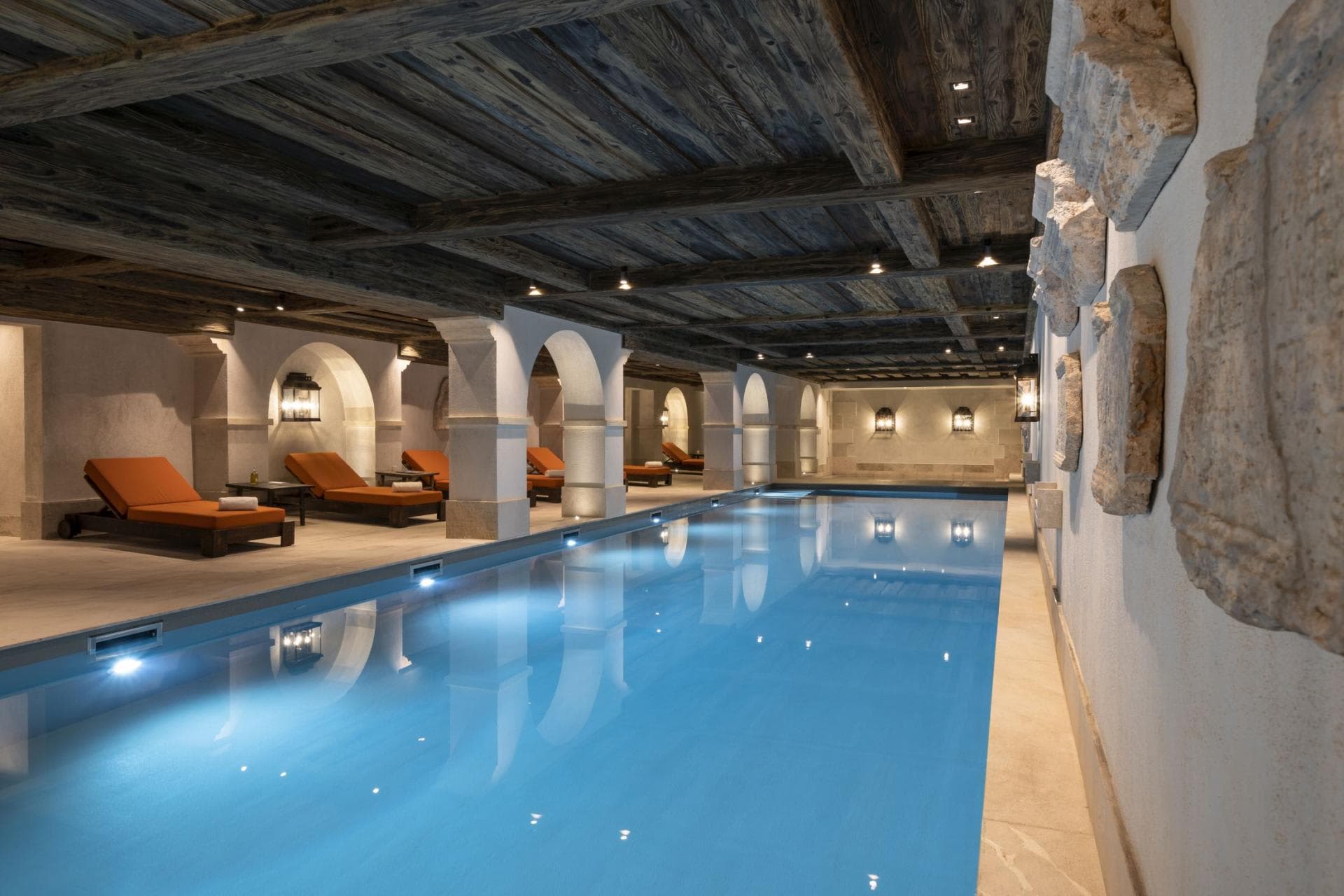 Indoor lap pool with timber ceilings and poolside loungers