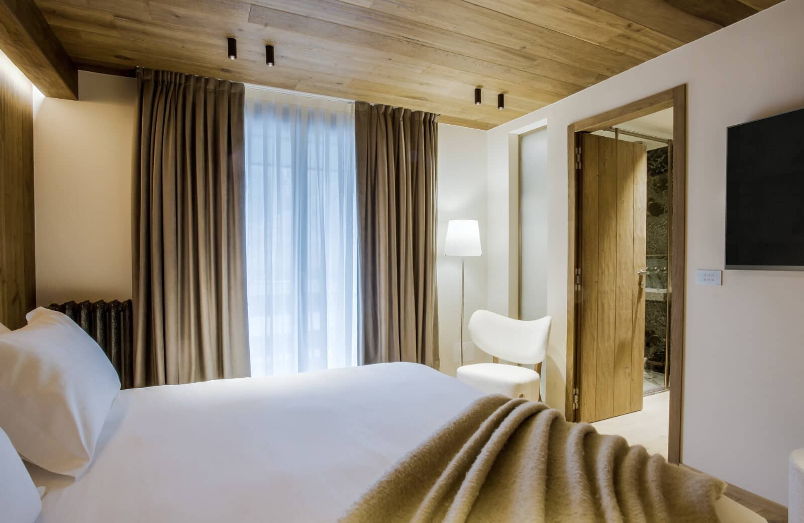 Guest bedroom with wood-paneled ceiling and ensuite stone-tiled shower