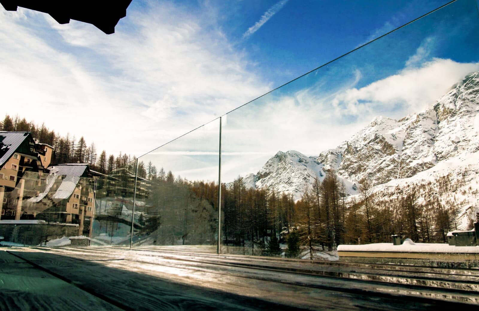 Private balcony with glass railing and mountain peak views