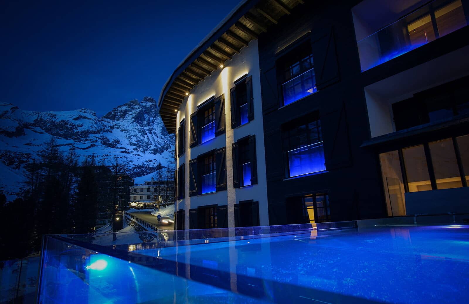Heated infinity pool with Matterhorn views and blue ambient lighting