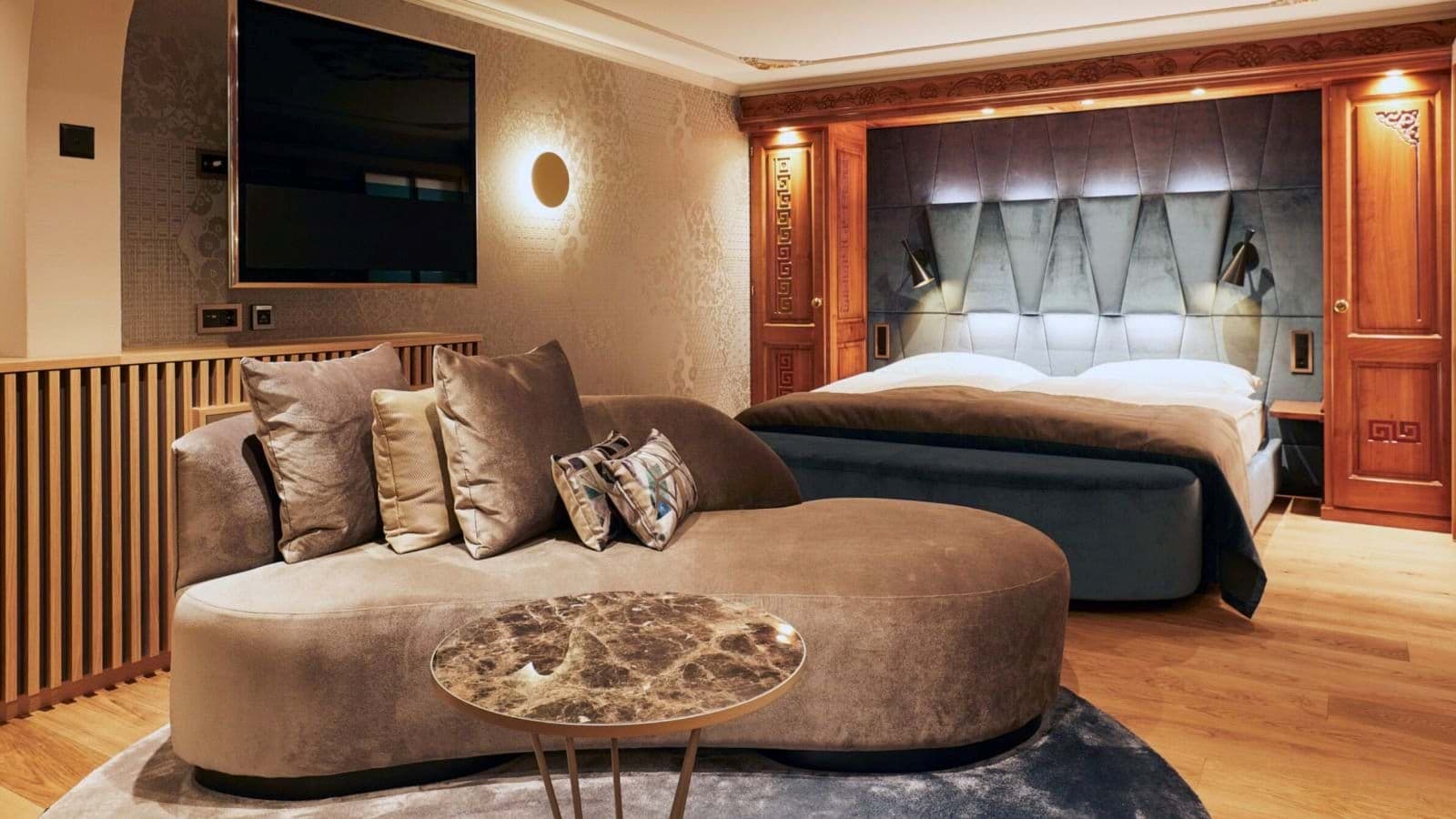 Primary bedroom with velvet chaise lounge and integrated wall storage