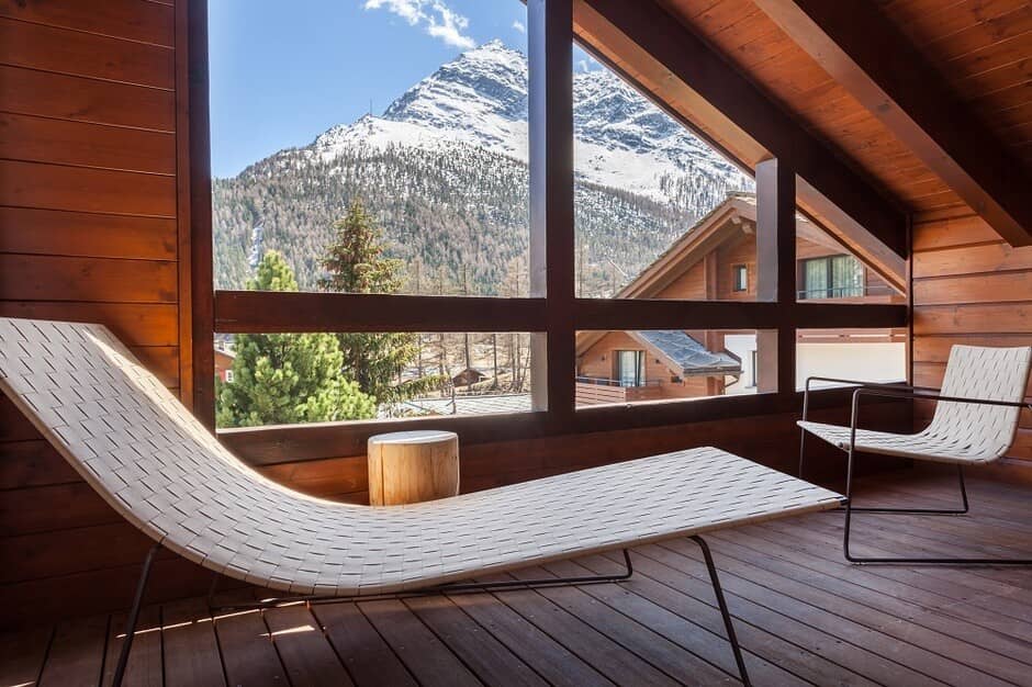 Enclosed wood-paneled balcony with lounge seating and Matterhorn views