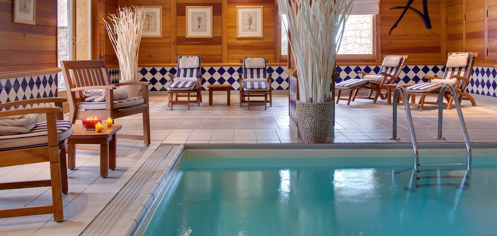 Indoor pool and spa area with heated lounge seating