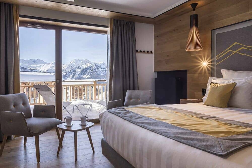 Primary bedroom with king bed and private balcony access to mountain views