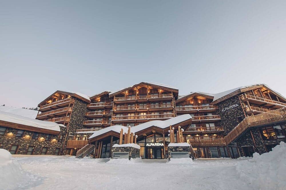 Ski-in ski-out lodge facade with private balconies and stone masonry