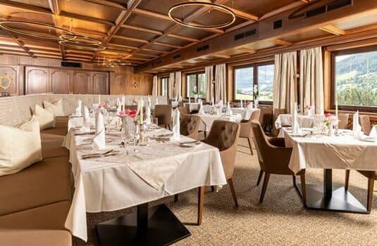 Dining room with wood-paneled ceiling, banquet seating, and mountain views