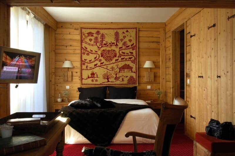 Log-walled bedroom with wall-mounted TV and built-in closet storage