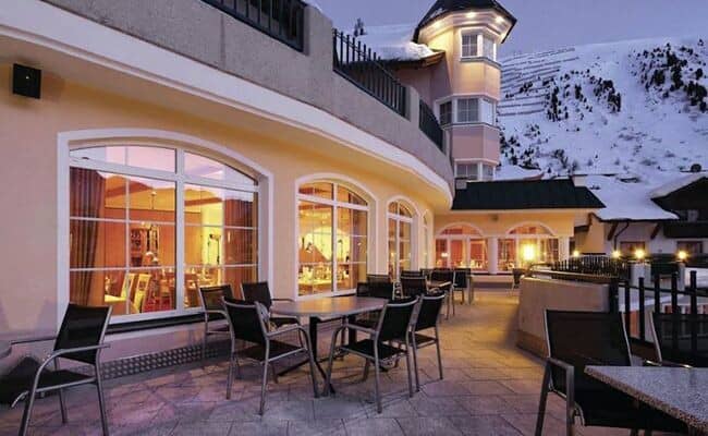 Stone patio with dining tables and direct ski slope views