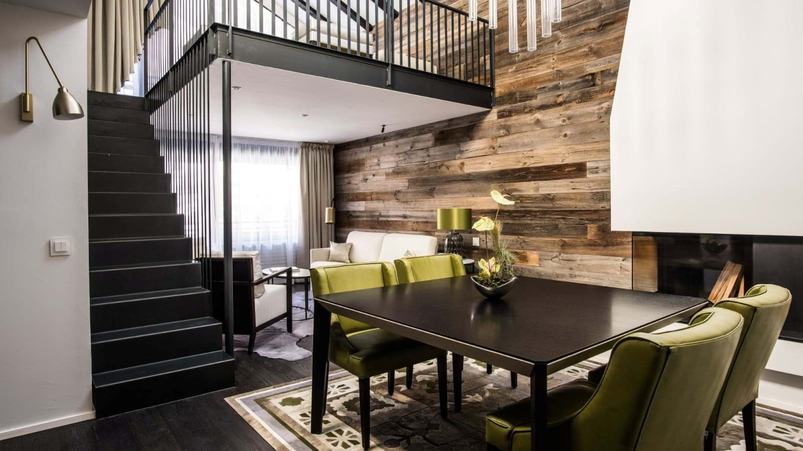 Open-plan living area with fireplace and loft access via steel staircase