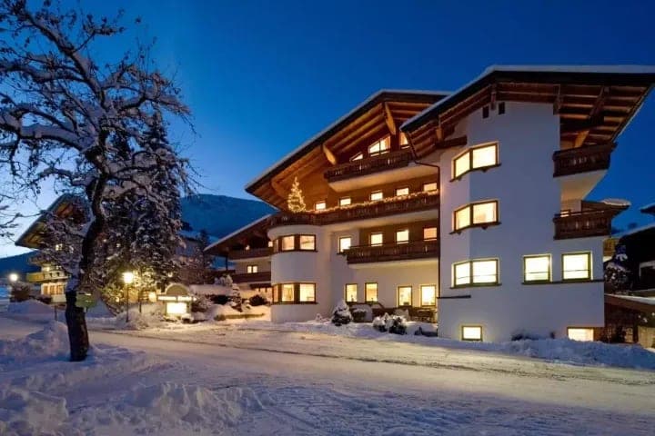 Chalet exterior at dusk with private balconies and mountain views