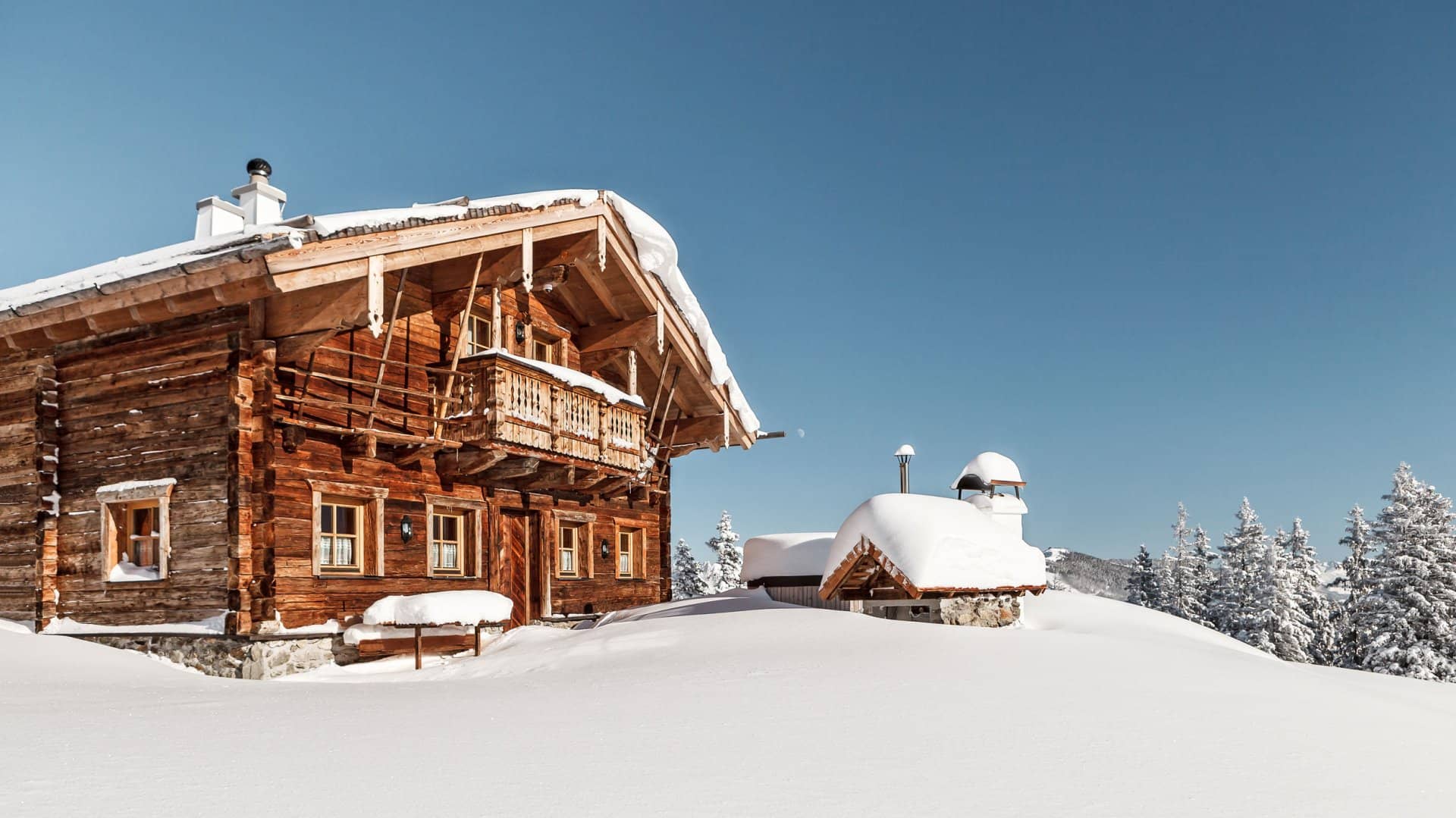 Ski-in chalet exterior featuring traditional log construction and private balcony