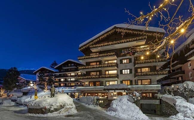 Chalet exterior at night with private balconies and village center proximity