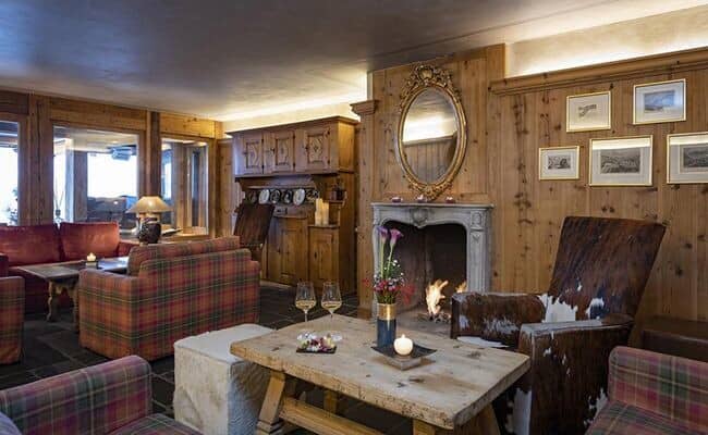 Wood-paneled lounge with wood-burning fireplace and cowhide armchairs