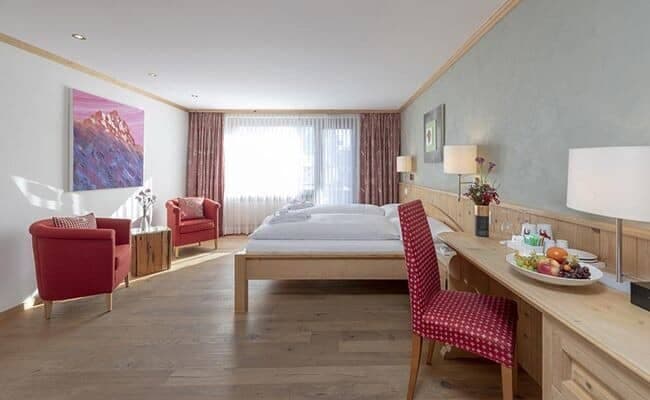 Guest bedroom with twin beds, reading nook, and built-in desk