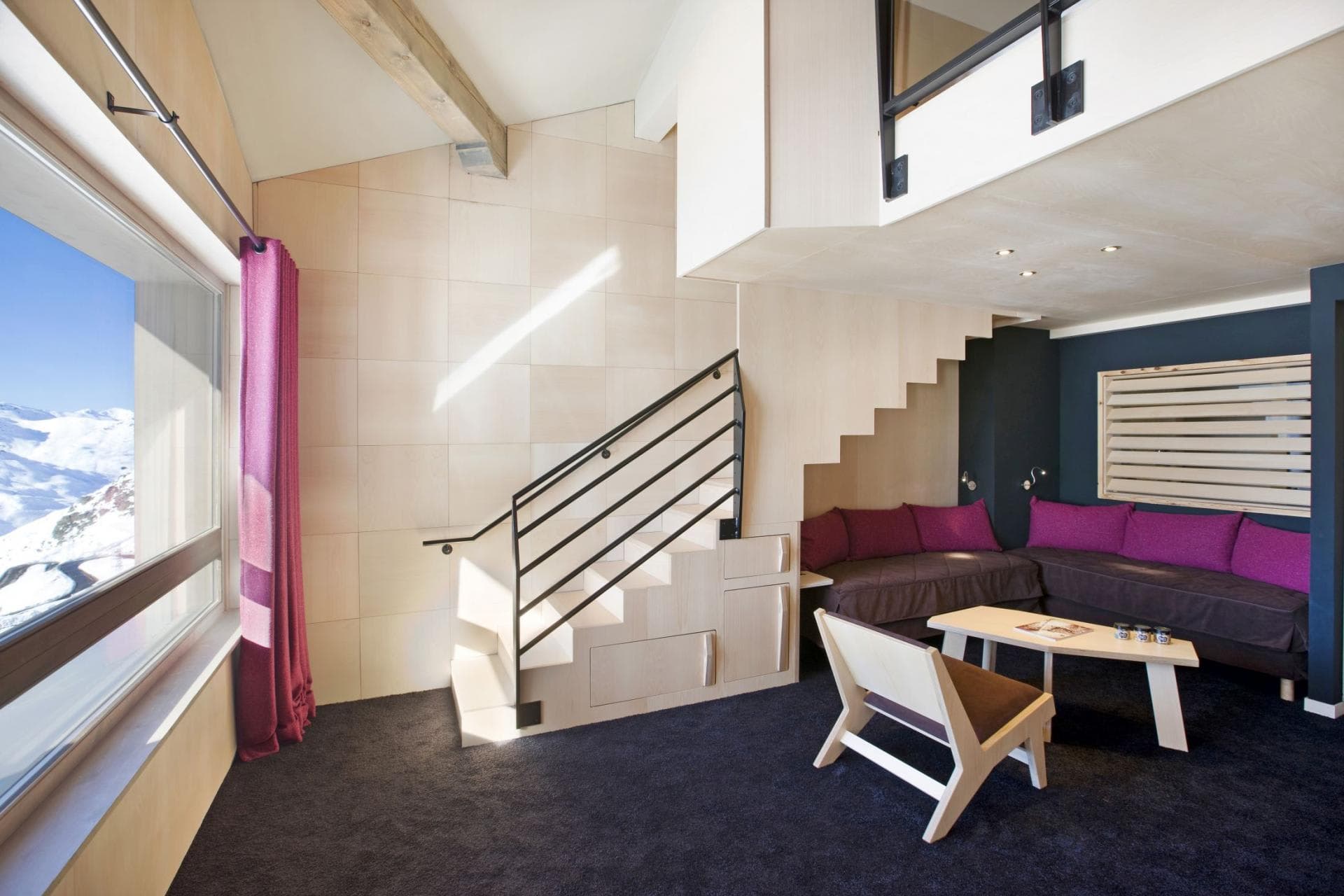 Living area with mountain views and loft access via storage stairs