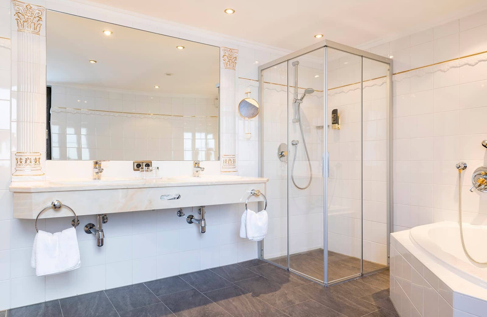 Bathroom with dual vanity, walk-in shower, and separate tub