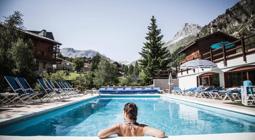 Shared outdoor pool with sun loungers and mountain views