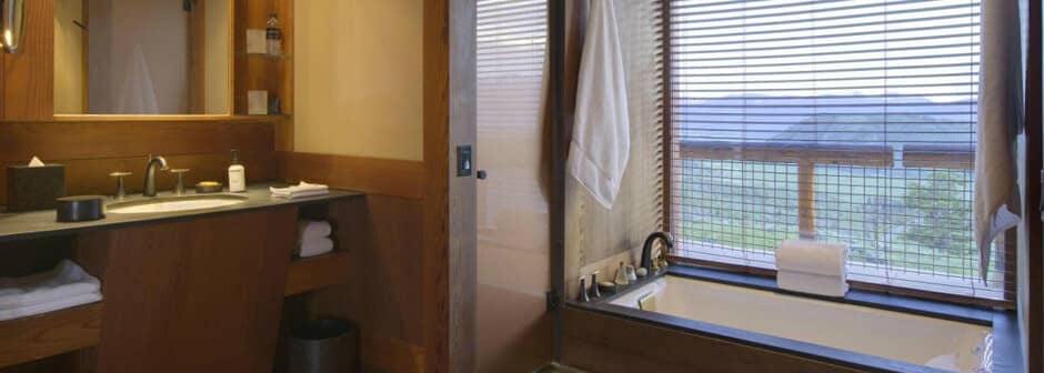 Bathroom featuring soaking tub with valley views and stone vanity