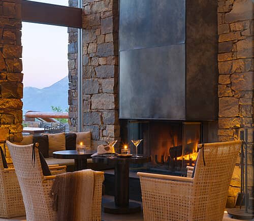 Stone lounge with wood-burning fireplace and mountain views