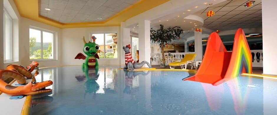 Indoor children's pool with rainbow slide and interactive water sprayers