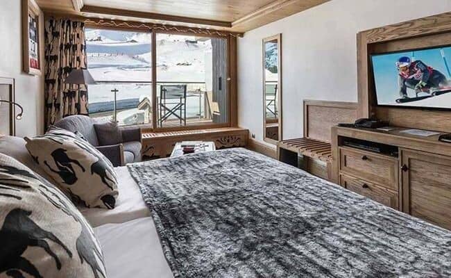 Primary bedroom with king bed and private balcony overlooking ski slopes