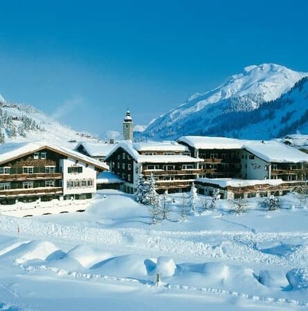 Ski-in/ski-out lodge exterior with village church and mountain views