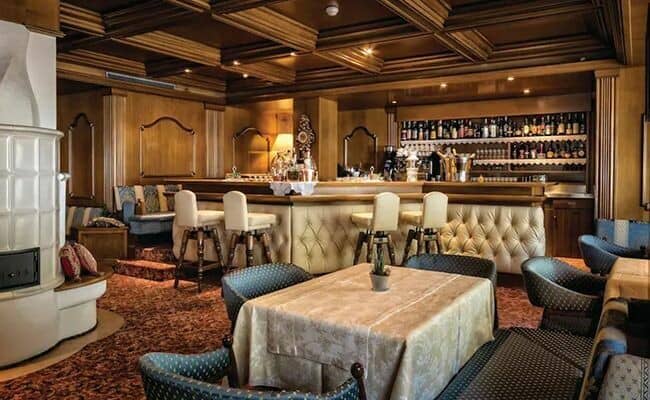 Private bar and lounge with wood-paneled ceilings and ceramic stove