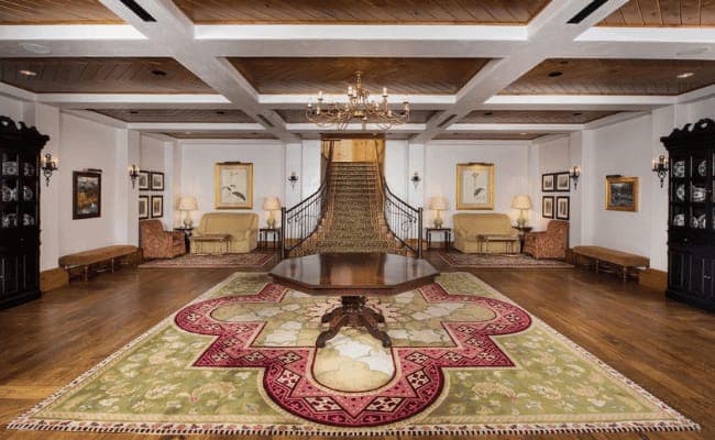 Foyer with grand staircase and coffered wood ceiling