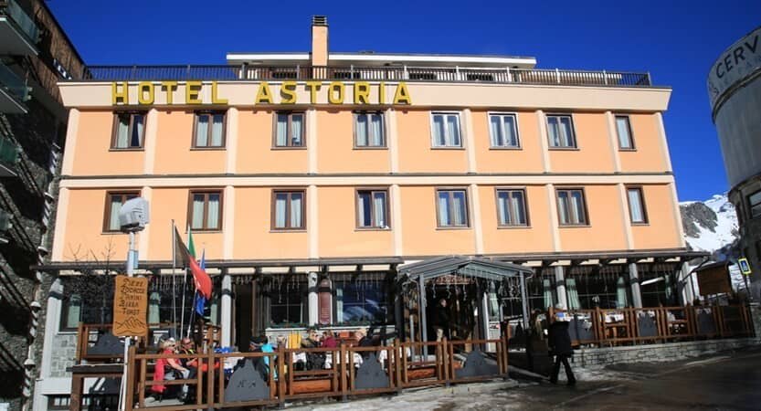 Hotel Astoria exterior with outdoor sun terrace and mountain views