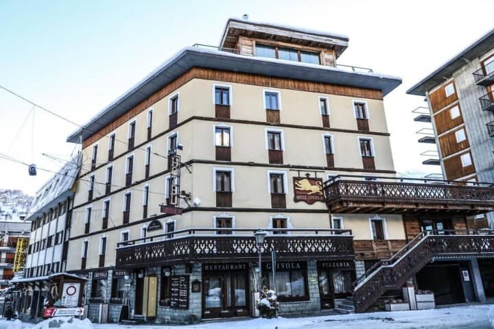 Hotel exterior with ground-floor pizzeria and shared balcony access