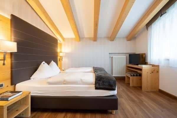 Guest bedroom with two twin mattresses and exposed wood ceiling beams