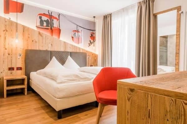 Guest bedroom with king bed, desk, and cable car mural