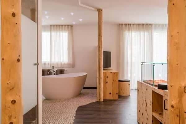 En suite bathroom with freestanding soaking tub and pebble tile flooring