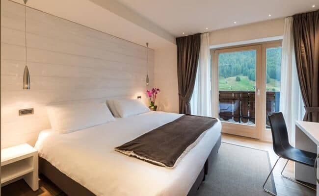 Bedroom with king bed, dedicated workspace, and private balcony