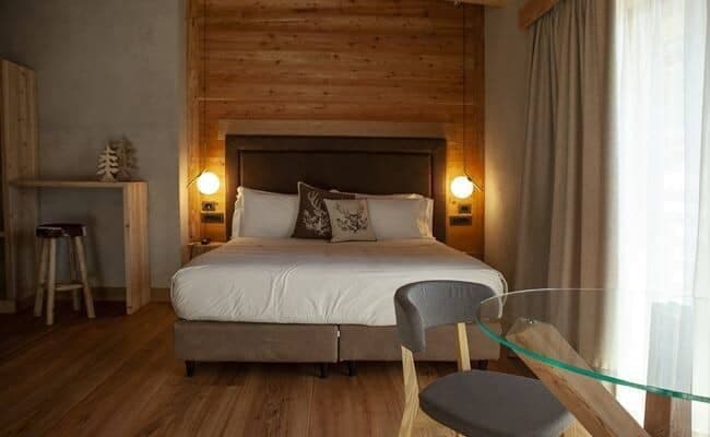 King bedroom with wood-paneled wall and dedicated desk area