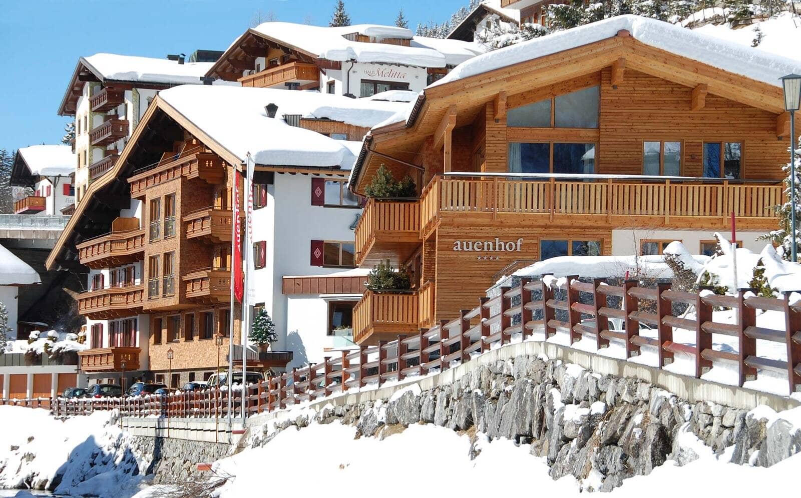 Ski-in chalet exterior featuring private balconies and designated guest parking