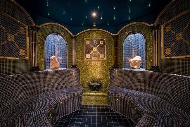 Mosaic-tiled steam room with heated bench seating and fiber optic ceiling